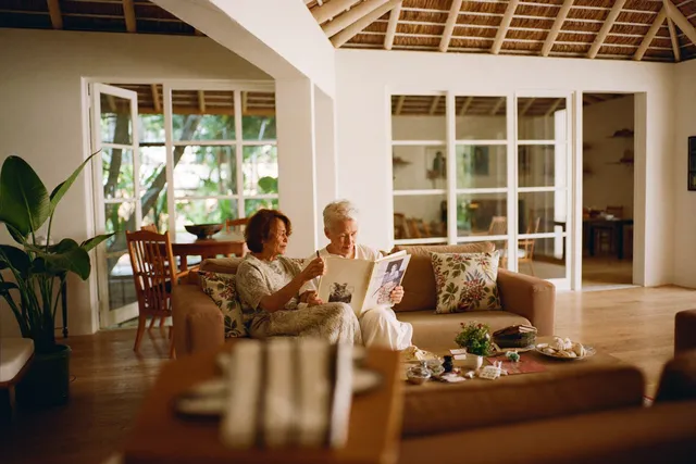 Caregiver looking at a photo album together with an elderly woman with dementia in Bali